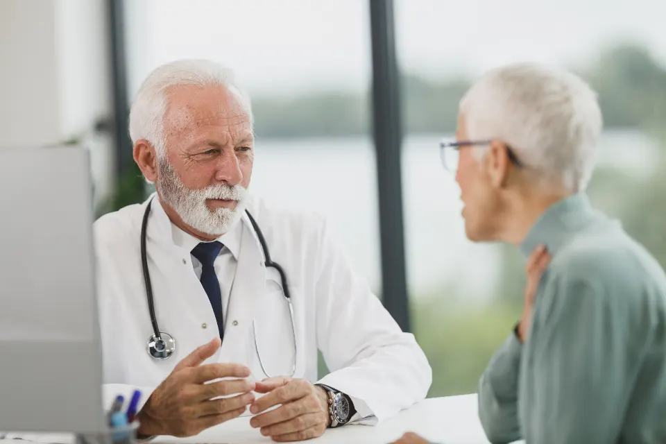 A physician listening to an older woman during a consultation