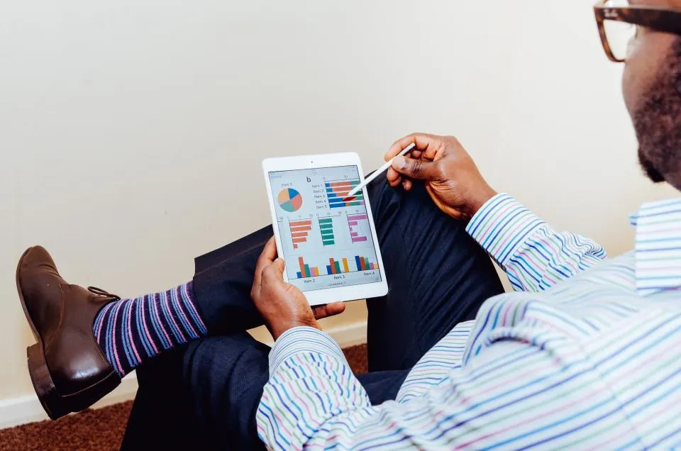 A person reviewing progress charts on a tablet